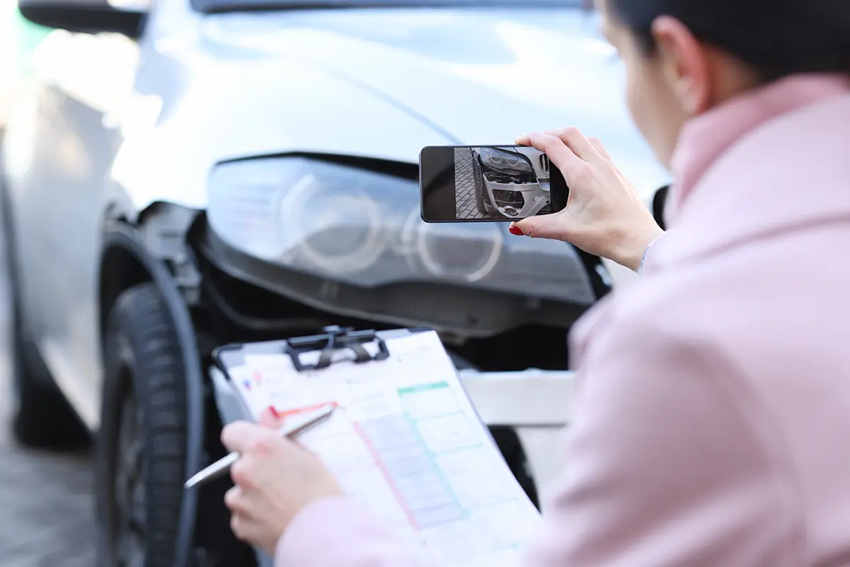 Professional inspecting a damaged car to prepare an auto body repair quote.