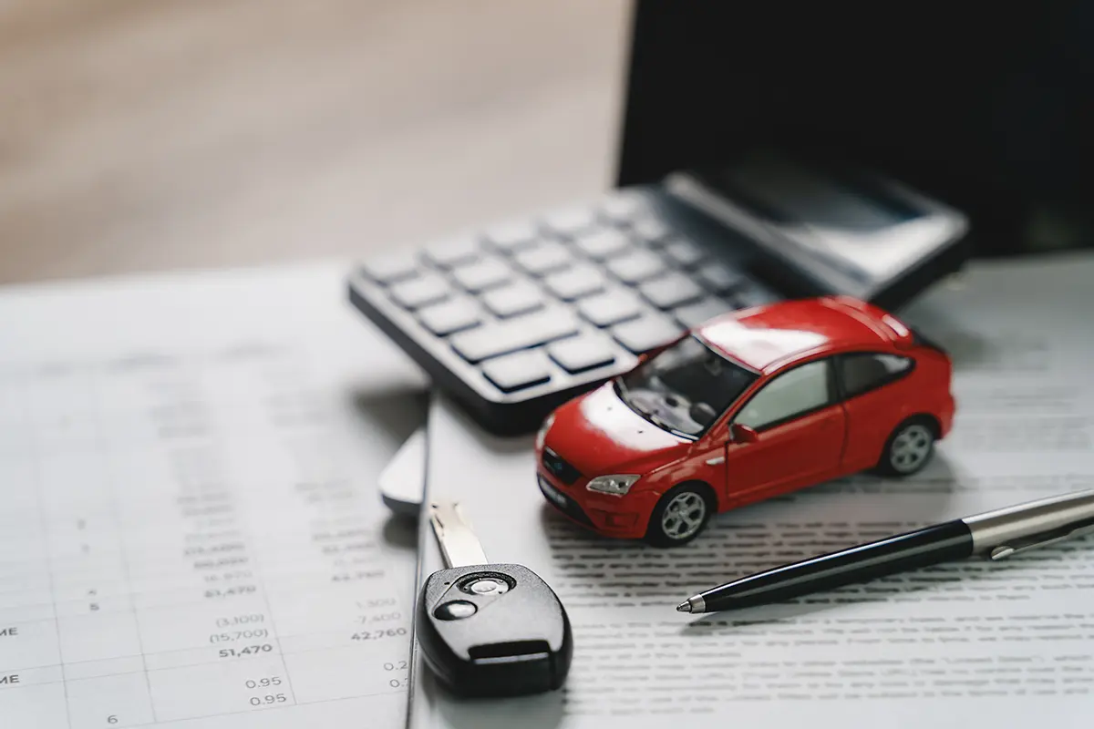 Office desk showing paperwork and a toy car to represent the vehicle repair process.