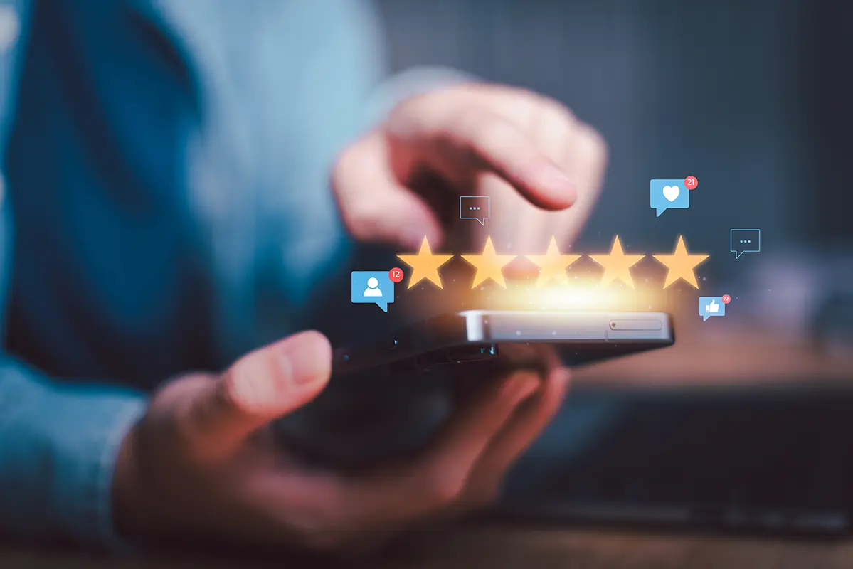 Hands holding a smartphone displaying a 5-star customer review rating.